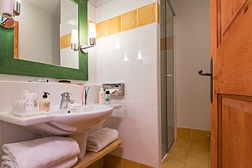 A bathroom with a sink and a green mirror