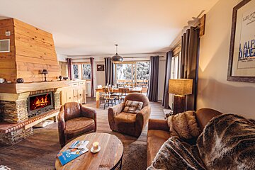 A living room with a fireplace and a poster that says alp d' huez