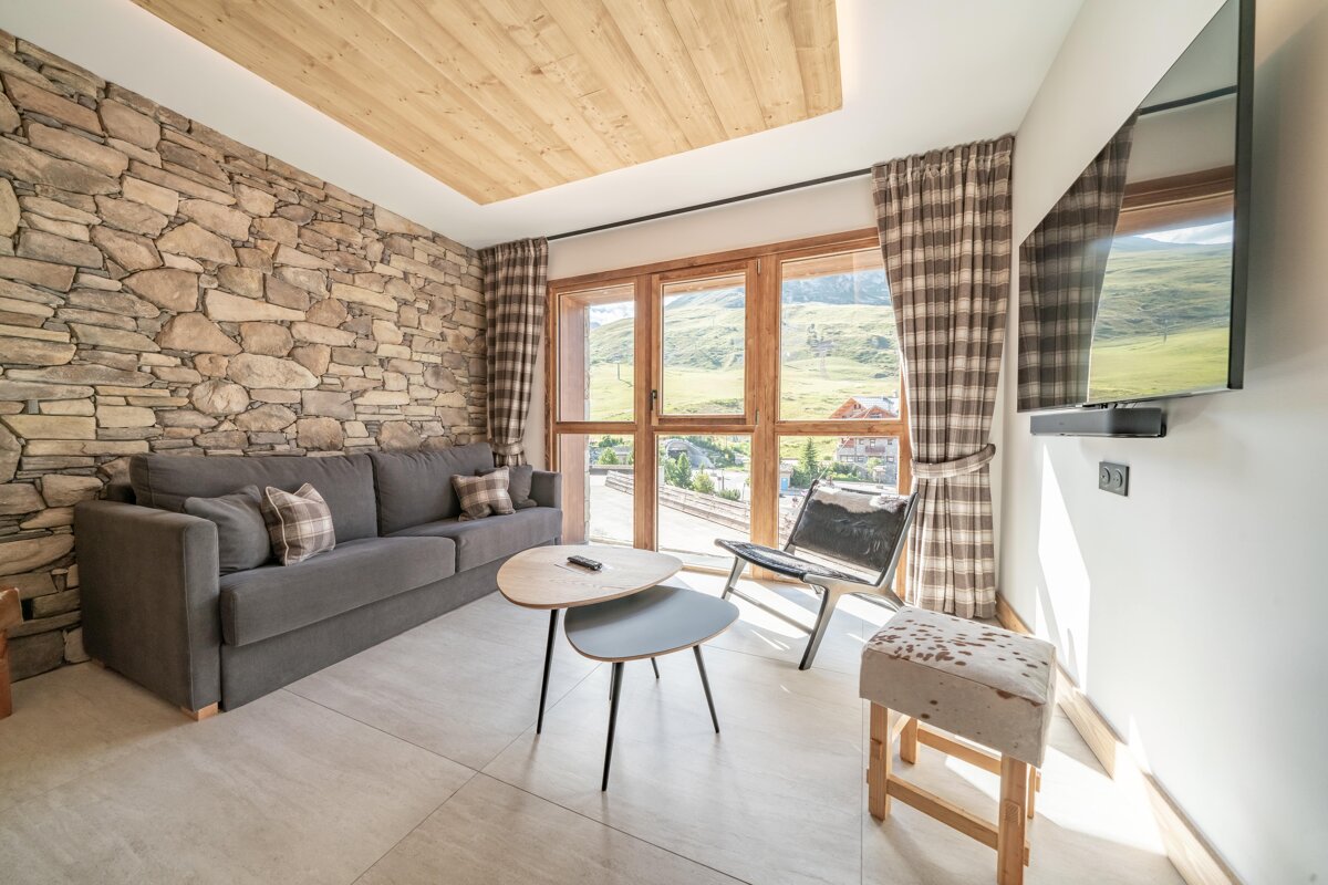 A living room with a stone wall and a flat screen tv