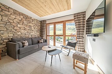 A living room with a stone wall and a flat screen tv