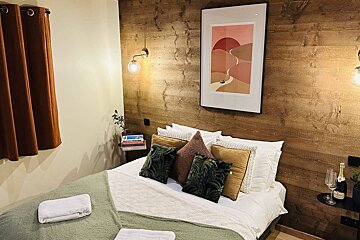 A bedroom with a bed and a picture on the wall