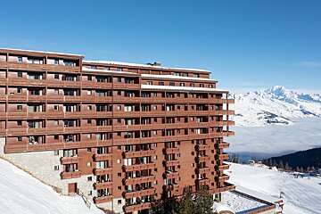 A large building with a mountain in the background