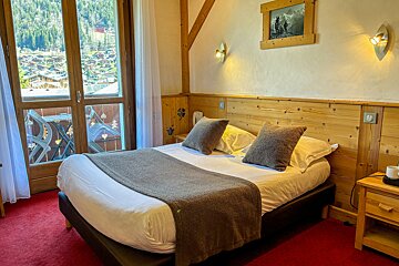 A hotel room with a bed and a picture on the wall