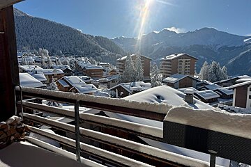 A view of a snowy mountain village from a balcony