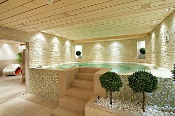 A hot tub in a room with a fire alarm on the ceiling