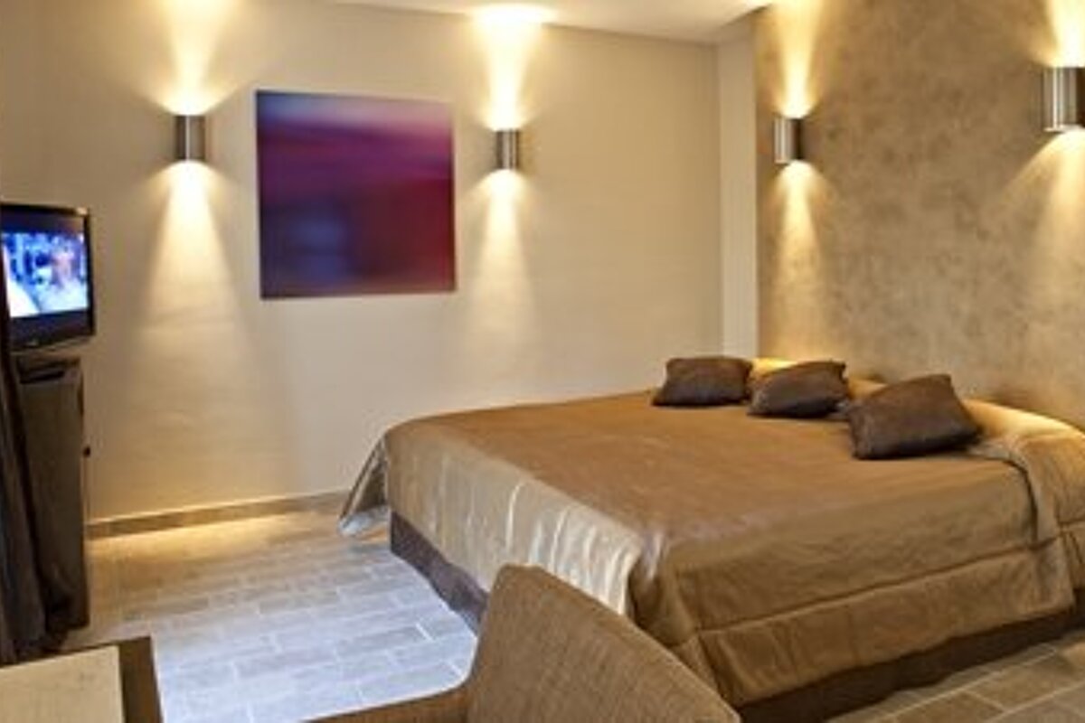 Large double bedroom with gold covered bed and modern silver light fittings