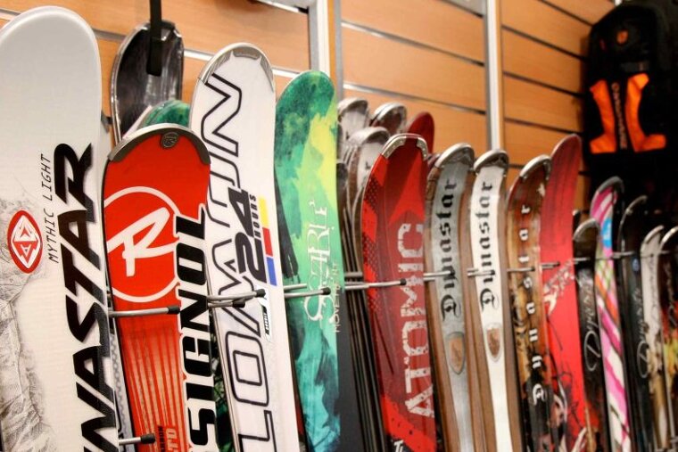 a picture of racks of skis lined up against the wall
