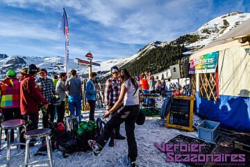 Picture of yurts outside in winter with skiers