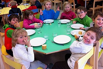 a picture of a table with lots of children sat around the edges