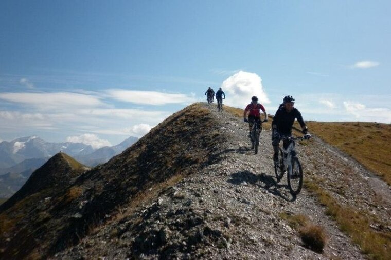 a picture of 4 mountain bikers on a gravelly ridge line