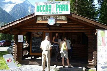A group of people are standing outside of a wooden building