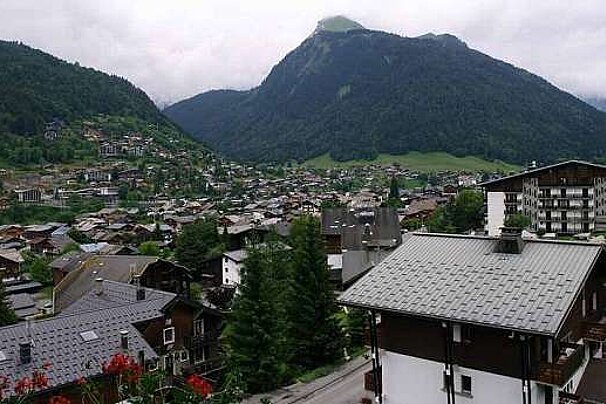 an image of a view from an apartment overlooking a town and mountains