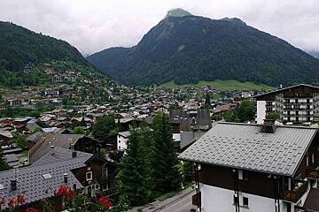 an image of a view from an apartment overlooking a town and mountains