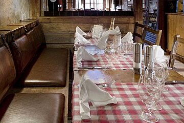 A table with a checkered table cloth and glasses on it