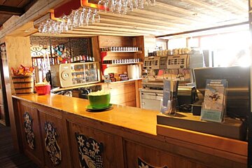 A counter in a restaurant with a sign that says 