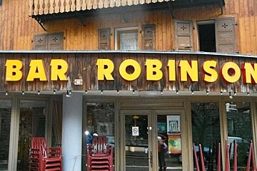 a picture of the front of a bar with plastic chairs piled up
