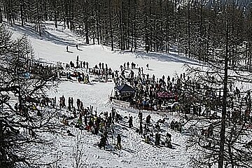 A large group of people are skiing down a snow covered slope