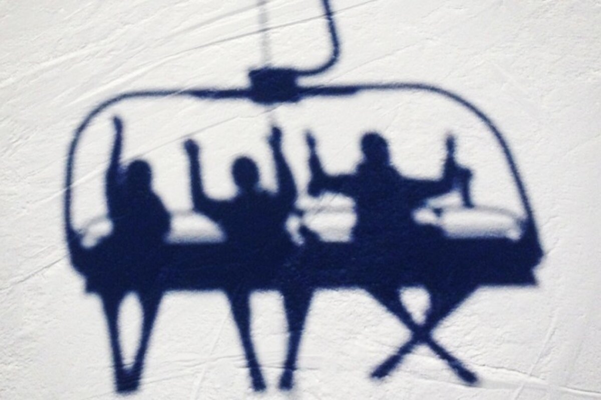 an image of people on a chairlift shadows