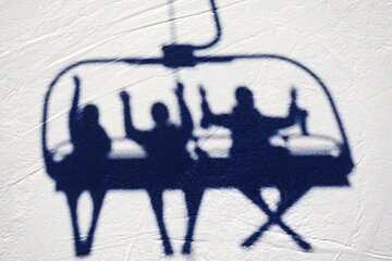 an image of people on a chairlift shadows