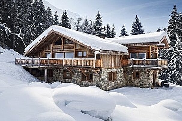 an image of a wood and stone chalet in the snow