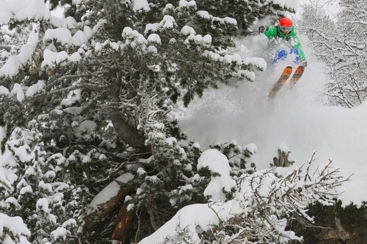 an image of a skier hucking a cliff in powder