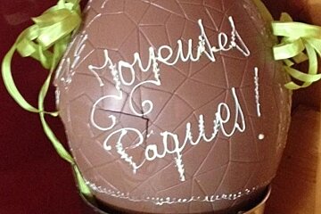 a picture of a large chocolate egg with happy easter written on in french