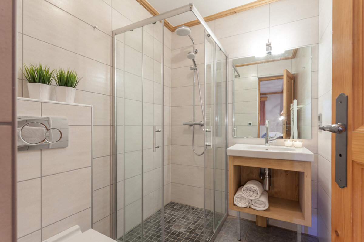 A bathroom with a walk in shower and a sink