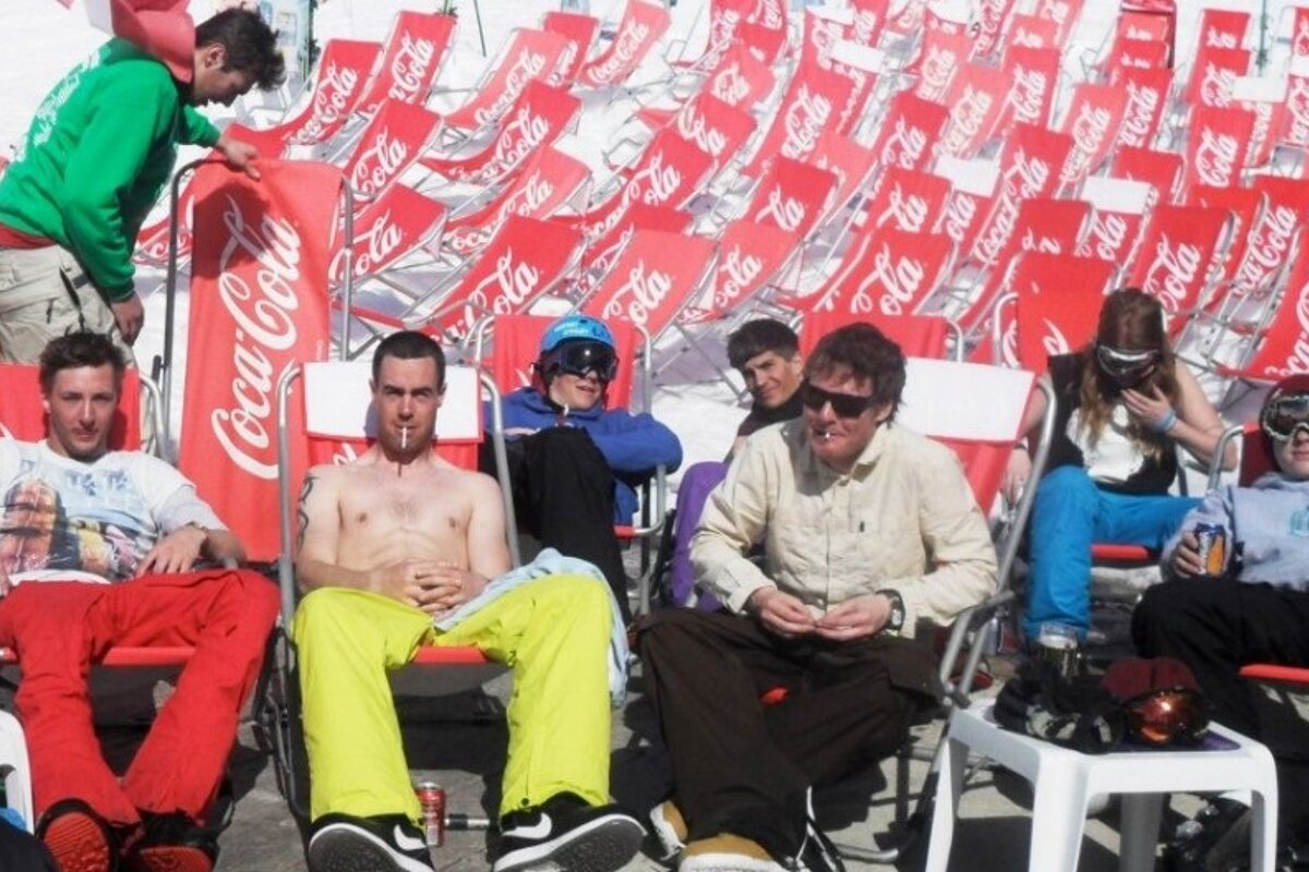 an image of people sunbathing on deckchairs in a ski resort