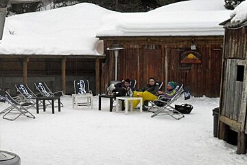 an image of people sitting in deckchairs in the snow