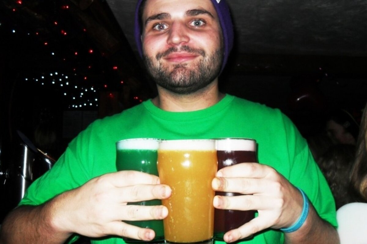 an image of a man holding coloured drinks