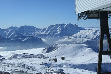 A ski lift is going up a snowy mountain