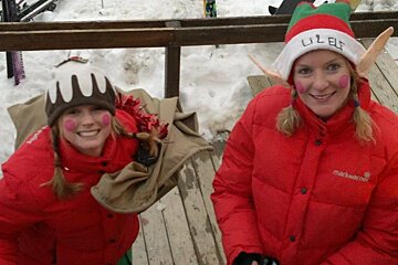 a picture of 2 girls dressed as santas elves