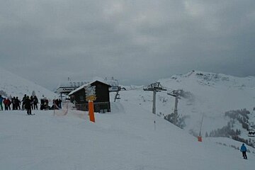 A ski lift is going up a snow covered mountain
