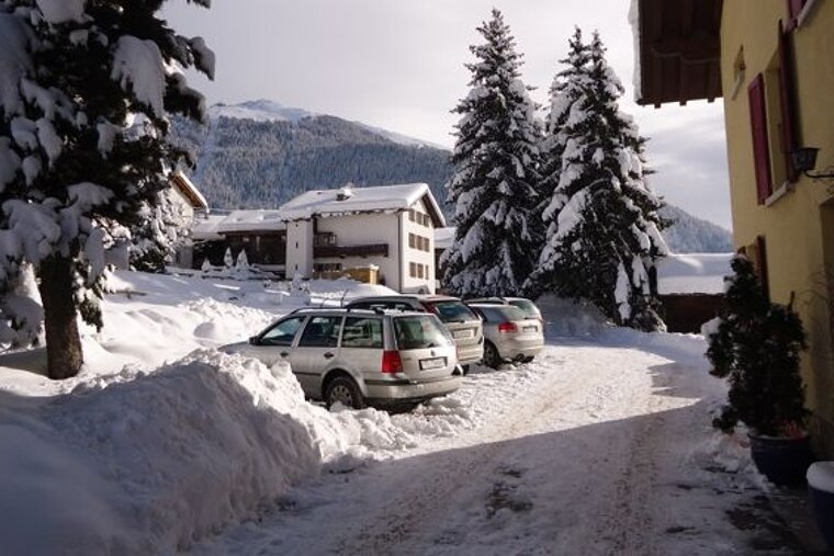 a picture of a parking space at a hotel in winter with lots of snow