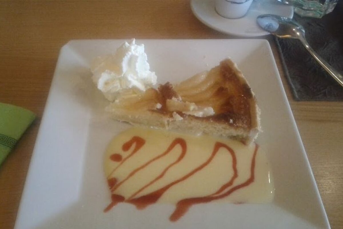 A white plate topped with a slice of pie and whipped cream