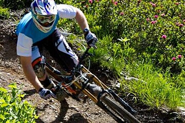 A man is riding a mountain bike down a trail