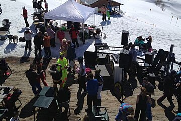 image of some people dancing with a DJ set up and tables and chairs, on a patio up the mountain