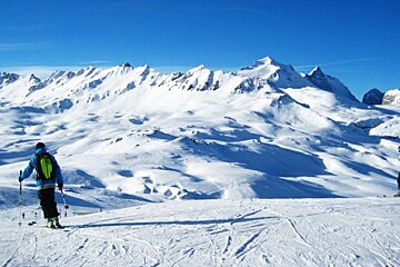 Top of Bellevarde piste sun and snow skier in foreground