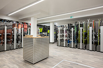A row of skis are lined up in a store
