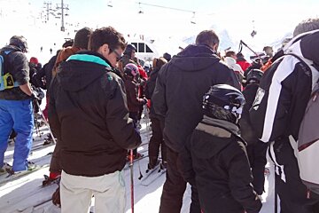 A group of skiers are waiting in line for a lift