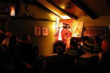An image of a stand-up comedian doing a show at an apres ski bar in Chamonix Mont Blanc with Mont Blanc glacier in background
