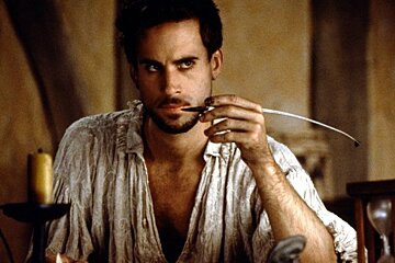 A man with a beard is holding a pen in his hand