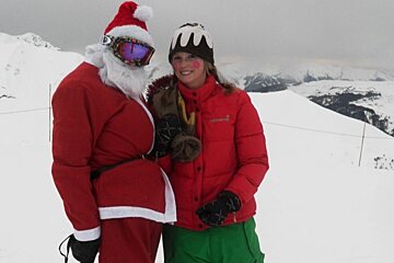 a picture of father christmas and an elf on the slopes