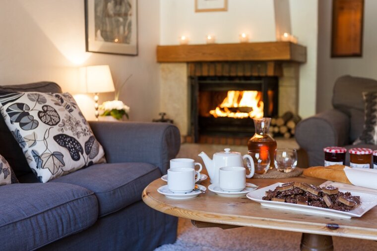A living room with a fireplace and a table with a plate of brownies on it