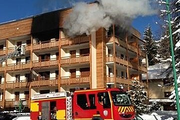 an image of a fire truck in front of an apartment on fire