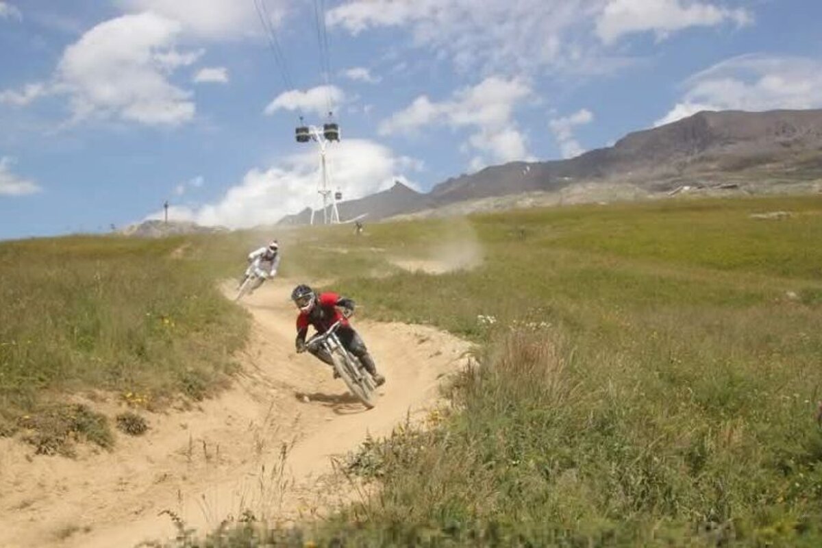 a picture of 2 bikers on a trail in alpe dhuez