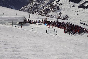 A large group of people are gathered on a snowy slope