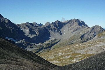 A view of a mountain range with a blue sky in the background