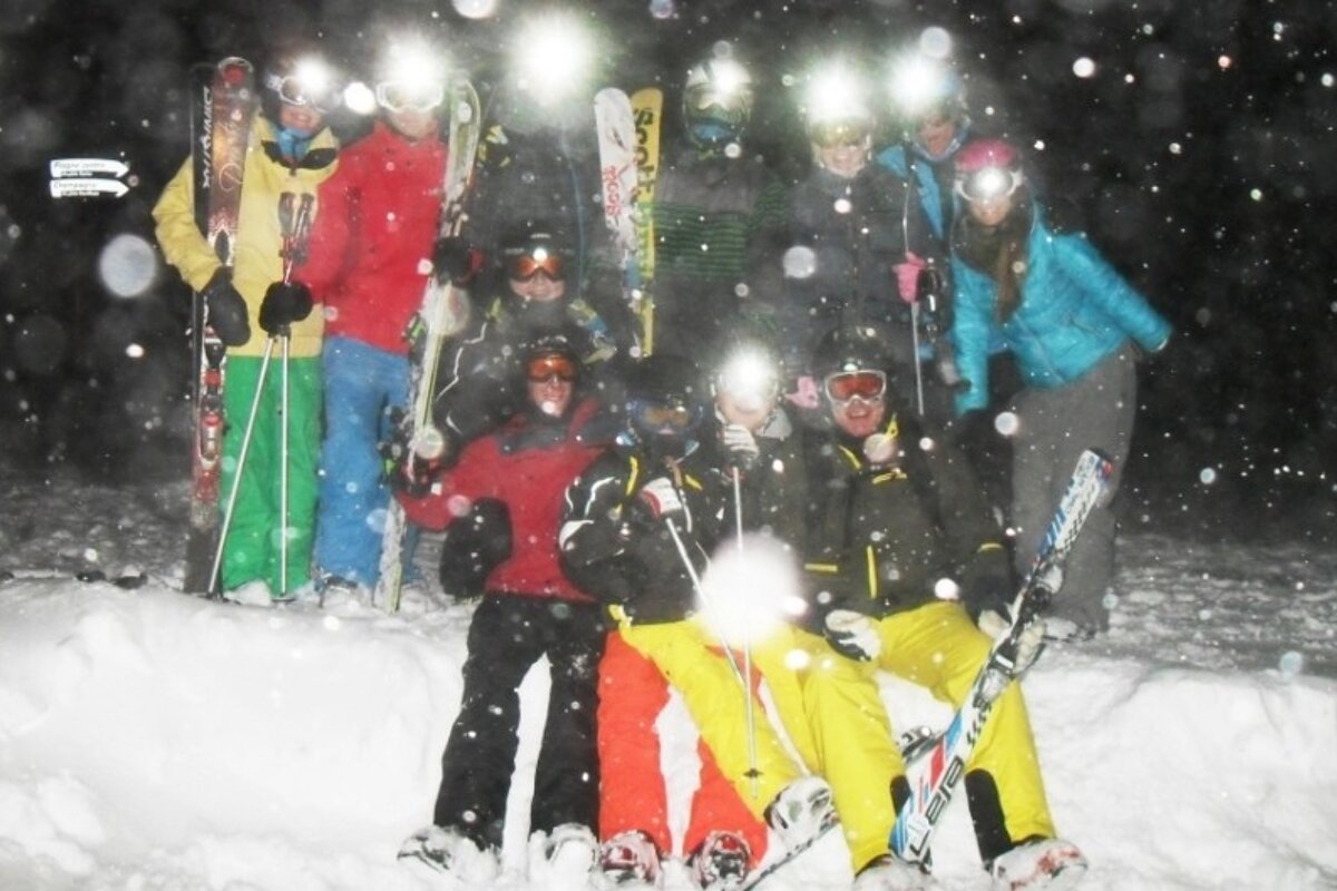 an image of a group of people getting ready to ski at night