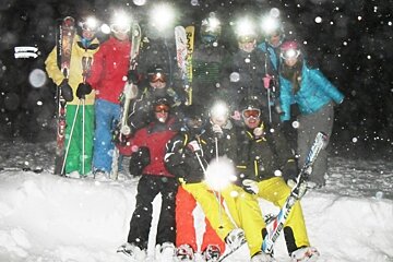 an image of a group of people getting ready to ski at night